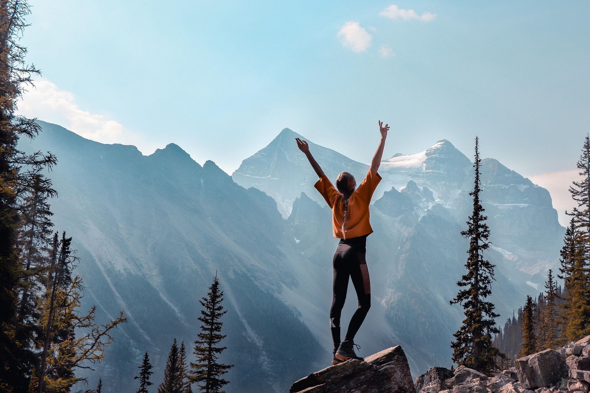 Woman raising her arms in victory on a mountain top