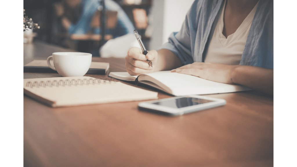 woman sitting at her desk writing down her midlife career change plan