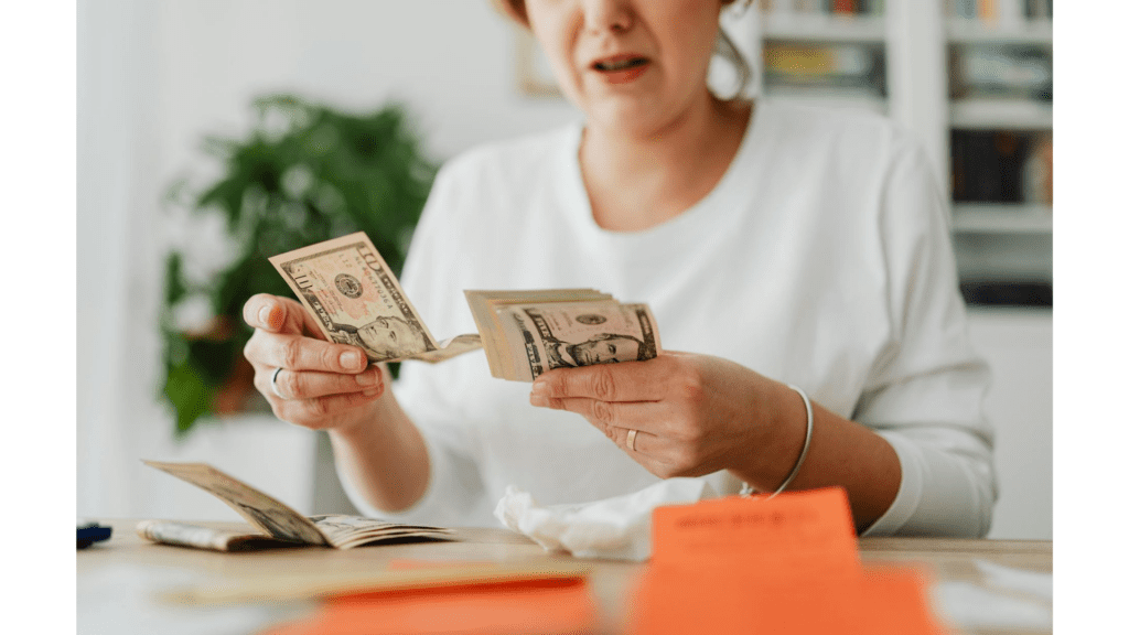 A midlife woman counting money working on figuring out her limiting beliefs about money